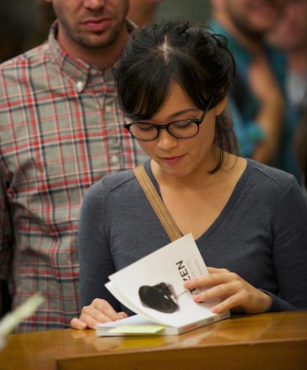 A reader paging through a copy of Citizen at an event at the Los Angeles Public Library
